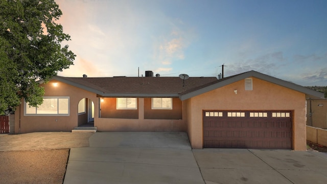 4509 Tottle Ave NW, Albuquerque, NM 87114 - view of front facade featuring stucco siding, driveway, a garage, and roof with shingles