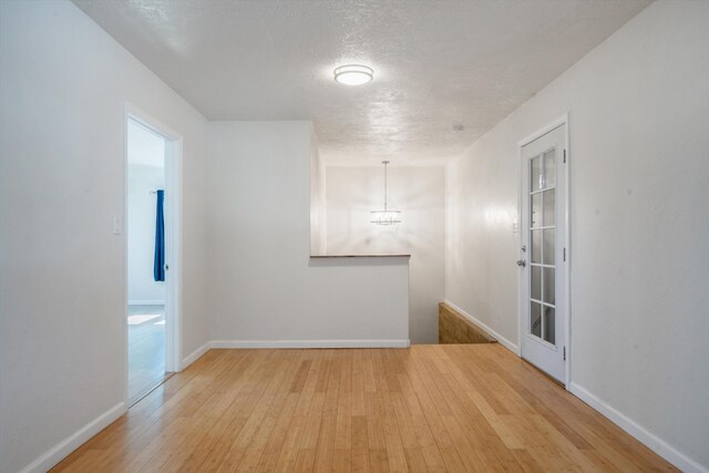 4509 Tottle Ave NW, Albuquerque, NM 87114 - unfurnished room featuring wood-type flooring, a chandelier, baseboards, and a textured ceiling