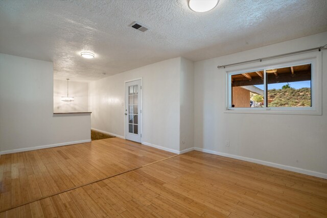 4509 Tottle Ave NW, Albuquerque, NM 87114 - spare room with a textured ceiling, hardwood / wood-style flooring, baseboards, and a chandelier