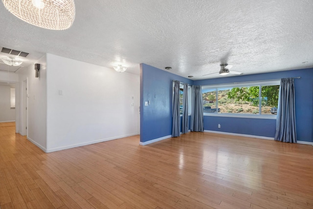 4509 Tottle Ave NW, Albuquerque, NM 87114 - empty room featuring a textured ceiling, light wood-type flooring, baseboards, and a chandelier