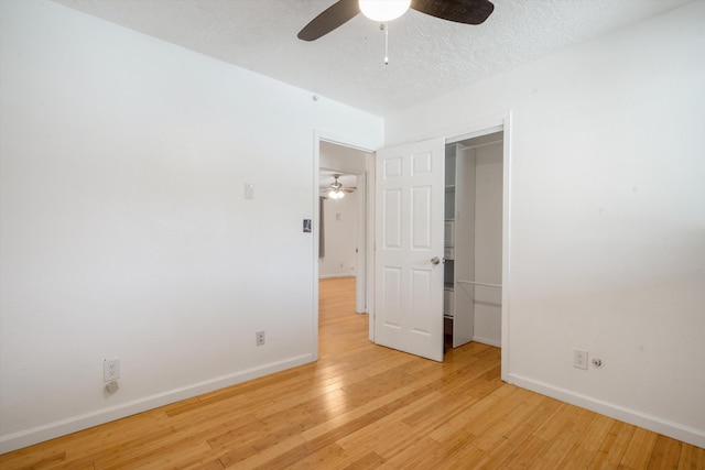 4509 Tottle Ave NW, Albuquerque, NM 87114 - unfurnished bedroom with light wood finished floors, baseboards, a textured ceiling, a ceiling fan, and a closet