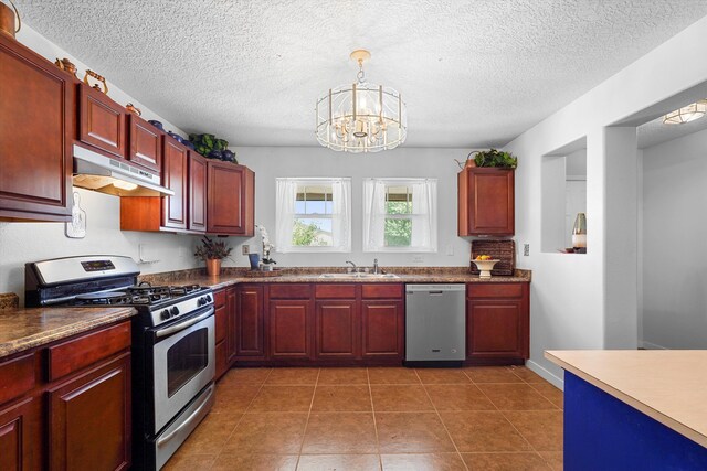 1951 Corta Rustica, Los Lunas, NM 87031 - kitchen with stainless steel appliances, under cabinet range hood, dark brown cabinets, a chandelier, and a textured ceiling