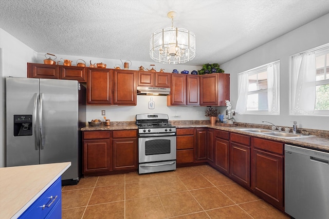 1951 Corta Rustica, Los Lunas, NM 87031 - kitchen with stainless steel appliances, under cabinet range hood, a chandelier, light tile patterned floors, and a textured ceiling