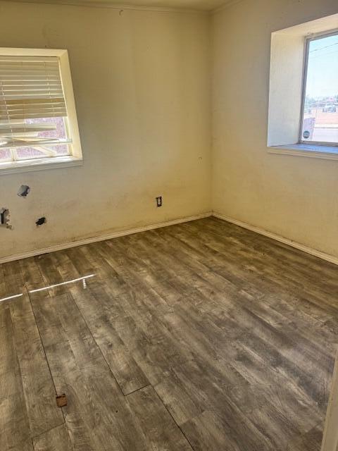 1212 W Reinken Ave, Belen, NM 87002 - spare room featuring dark wood-style floors and baseboards