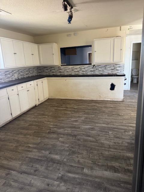 1212 W Reinken Ave, Belen, NM 87002 - kitchen with dark countertops, white cabinetry, and tasteful backsplash