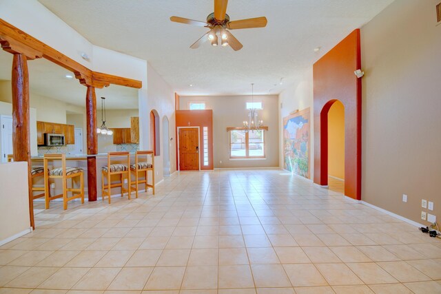 2705 Pueblo Grande Trl NW, Albuquerque, NM 87120 - unfurnished living room with a chandelier, ceiling fan, arched walkways, and light tile patterned floors