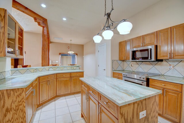 2705 Pueblo Grande Trl NW, Albuquerque, NM 87120 - kitchen featuring appliances with stainless steel finishes, backsplash, light stone countertops, a center island, and a peninsula