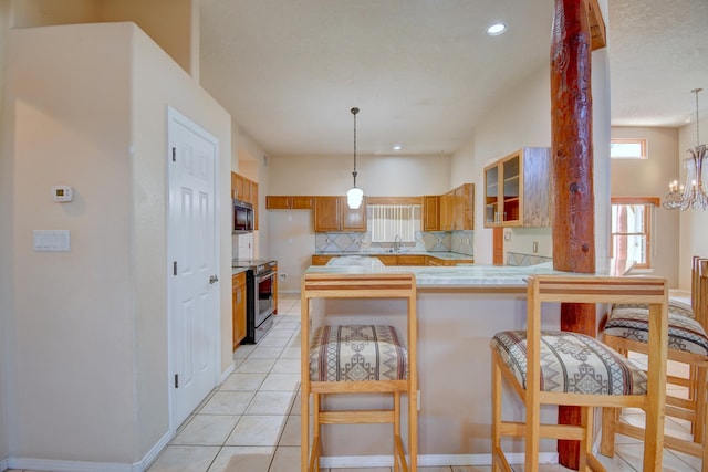 2705 Pueblo Grande Trl NW, Albuquerque, NM 87120 - kitchen with stainless steel appliances, tasteful backsplash, a peninsula, a sink, and brown cabinetry