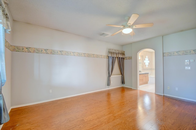 2705 Pueblo Grande Trl NW, Albuquerque, NM 87120 - unfurnished room with arched walkways, ceiling fan, wood finished floors, and baseboards