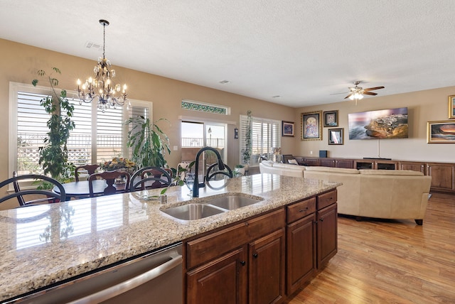 4210 Agave Ct SW, Los Lunas, NM 87031 - kitchen with a sink, dishwasher, light stone counters, a chandelier, and light wood-type flooring