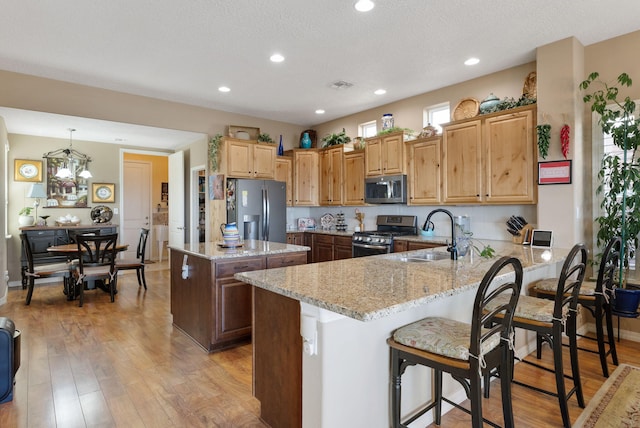 4210 Agave Ct SW, Los Lunas, NM 87031 - kitchen featuring stainless steel appliances, a sink, a peninsula, light stone countertops, and recessed lighting