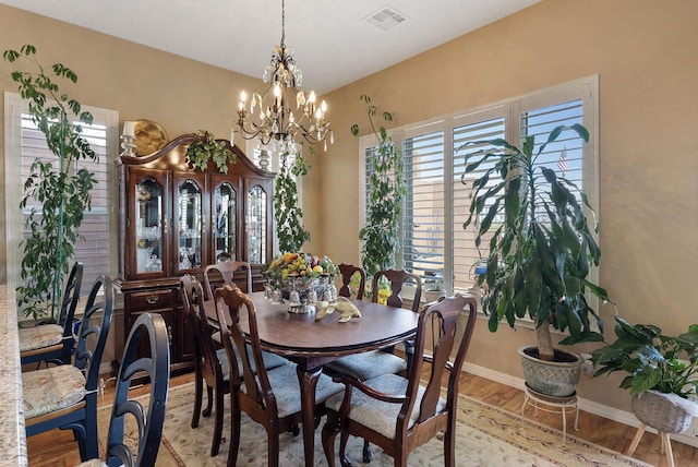 4210 Agave Ct SW, Los Lunas, NM 87031 - dining space featuring light wood finished floors, a chandelier, and baseboards
