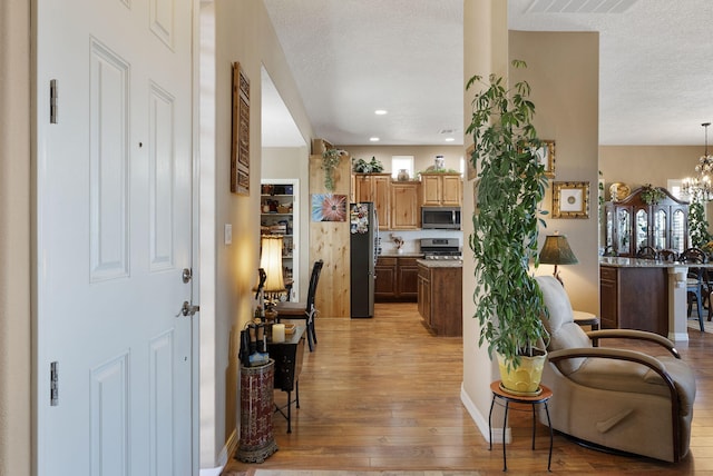 4210 Agave Ct SW, Los Lunas, NM 87031 - entryway with light wood-style floors, a textured ceiling, a chandelier, recessed lighting, and baseboards