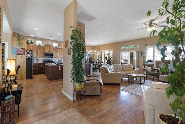 4210 Agave Ct SW, Los Lunas, NM 87031 - living area with hardwood / wood-style floors, a ceiling fan, plenty of natural light, a textured ceiling, and a chandelier