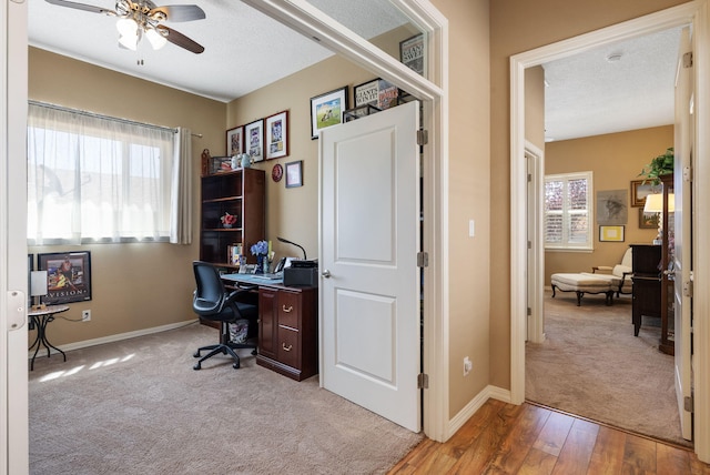 4210 Agave Ct SW, Los Lunas, NM 87031 - home office featuring a ceiling fan, plenty of natural light, light carpet, light wood-style flooring, and a textured ceiling