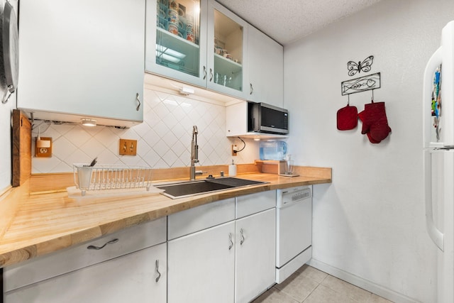 3867 Montgomery Blvd NE Unit 1633, Albuquerque, NM 87109 - kitchen featuring white appliances, a sink, butcher block countertops, tasteful backsplash, and light tile patterned flooring