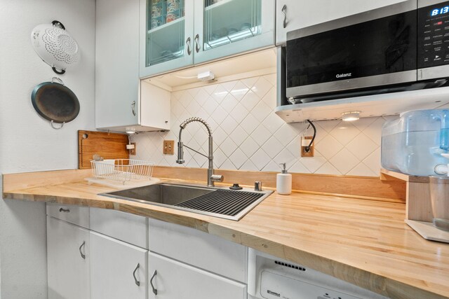 3867 Montgomery Blvd NE Unit 1633, Albuquerque, NM 87109 - kitchen featuring stainless steel microwave, wood counters, a sink, and backsplash