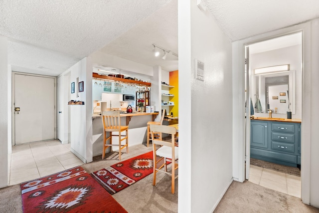 3867 Montgomery Blvd NE Unit 1633, Albuquerque, NM 87109 - corridor with tile patterned flooring, a textured ceiling, baseboards, carpet floors, and rail lighting