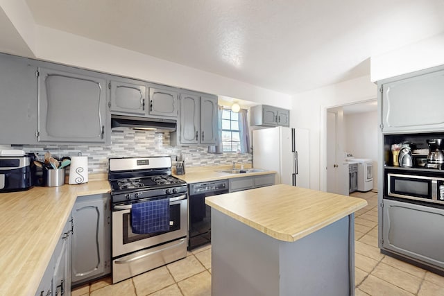 648 Frederico Blvd, Rio Communities, NM 87002 - kitchen with stainless steel appliances, under cabinet range hood, gray cabinets, a sink, and independent washer and dryer
