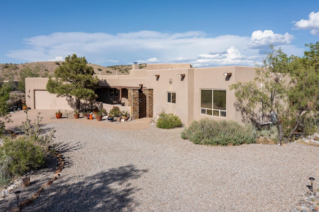 1 Seasons Cir, Placitas, NM 87043 - pueblo-style home with concrete driveway, stucco siding, and a garage