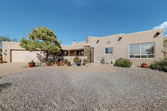 1 Seasons Cir, Placitas, NM 87043 - pueblo-style house featuring a garage, stucco siding, and concrete driveway