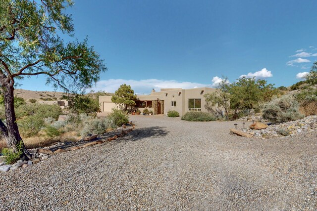1 Seasons Cir, Placitas, NM 87043 - view of front facade featuring stucco siding and gravel driveway