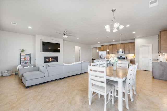 3217 Vatapa Rd NE, Rio Rancho, NM 87144 - dining room with arched walkways, a ceiling fan, light tile patterned floors, recessed lighting, and a chandelier