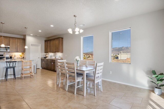 3217 Vatapa Rd NE, Rio Rancho, NM 87144 - dining room featuring a chandelier, recessed lighting, a textured ceiling, baseboards, and light tile patterned floors