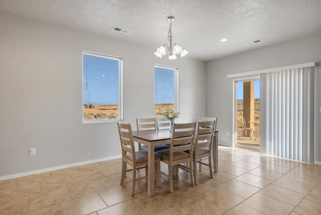 3217 Vatapa Rd NE, Rio Rancho, NM 87144 - dining area featuring a chandelier, baseboards, a textured ceiling, and light tile patterned flooring