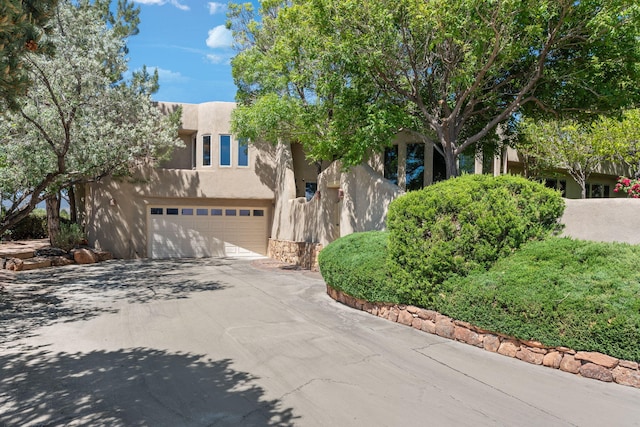 1572 Eagle Ridge Ct NE, Albuquerque, NM 87122 - pueblo revival-style home with stucco siding, concrete driveway, and an attached garage
