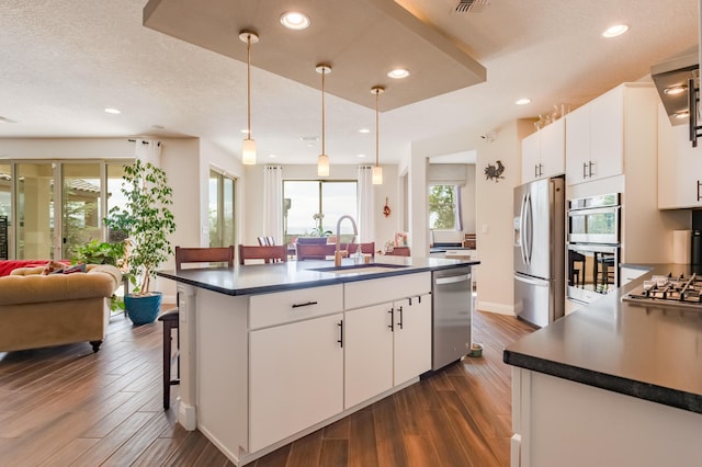1608 Mammoth Way, Albuquerque, NM 87120 - kitchen with stainless steel appliances, a sink, dark countertops, dark wood-style flooring, and white cabinets