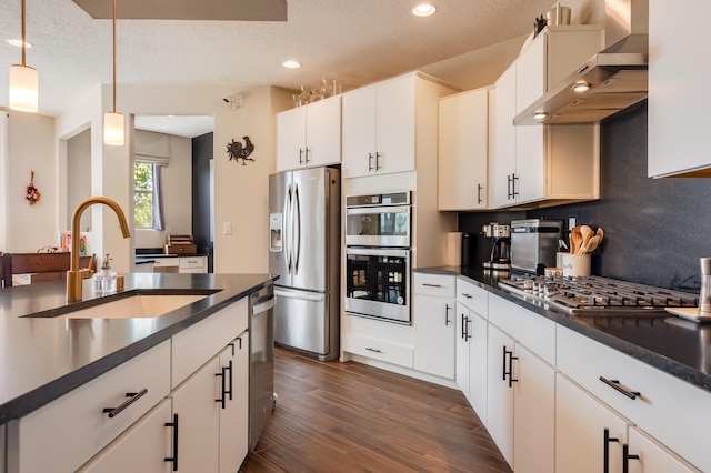 1608 Mammoth Way, Albuquerque, NM 87120 - kitchen with appliances with stainless steel finishes, wall chimney exhaust hood, a sink, dark countertops, and recessed lighting