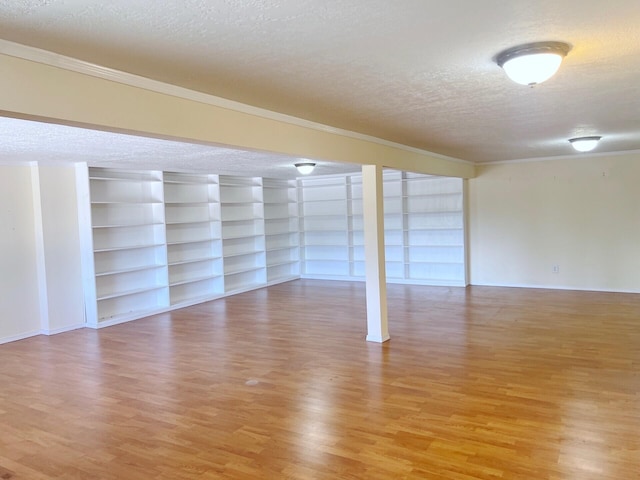 10008 Greene Ave NW, Albuquerque, NM 87114 - empty room featuring a textured ceiling, light wood-style flooring, crown molding, built in features, and baseboards