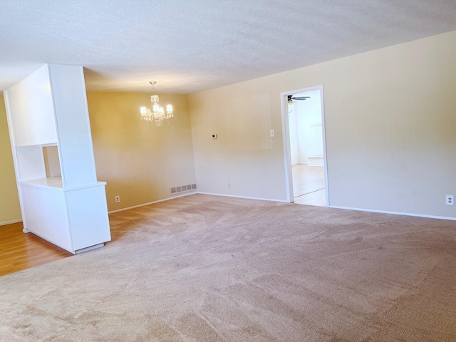 10008 Greene Ave NW, Albuquerque, NM 87114 - spare room featuring light carpet, a chandelier, baseboards, and a textured ceiling