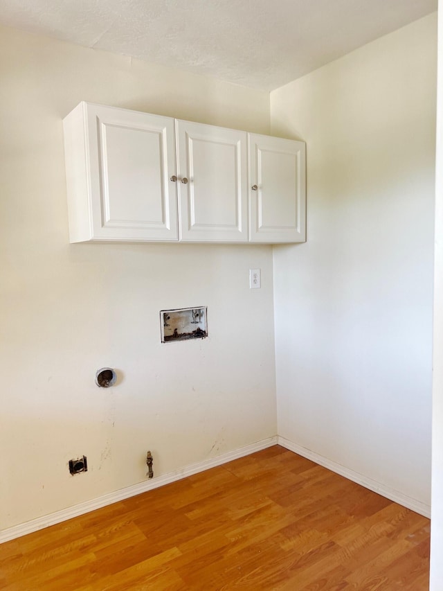 10008 Greene Ave NW, Albuquerque, NM 87114 - laundry area featuring cabinet space, hookup for a washing machine, light wood finished floors, baseboards, and gas dryer hookup