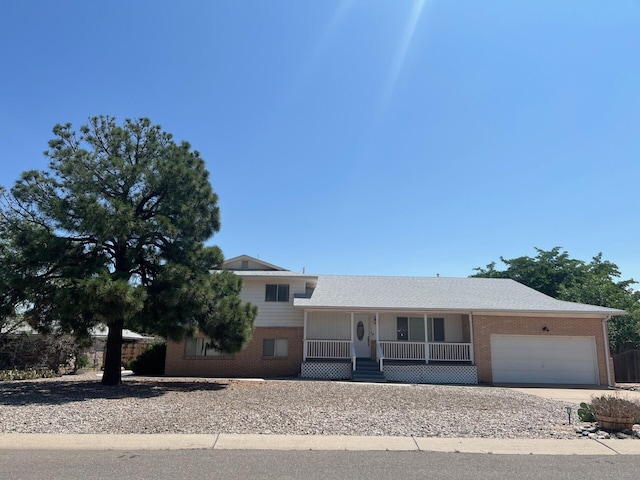 10008 Greene Ave NW, Albuquerque, NM 87114 - tri-level home with covered porch, brick siding, a garage, and concrete driveway