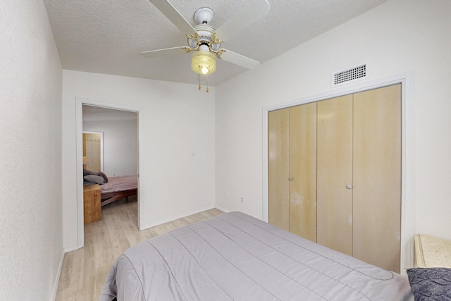 1128 Pandora Dr SW, Los Lunas, NM 87031 - bedroom featuring wood finished floors, baseboards, a ceiling fan, a closet, and a textured ceiling
