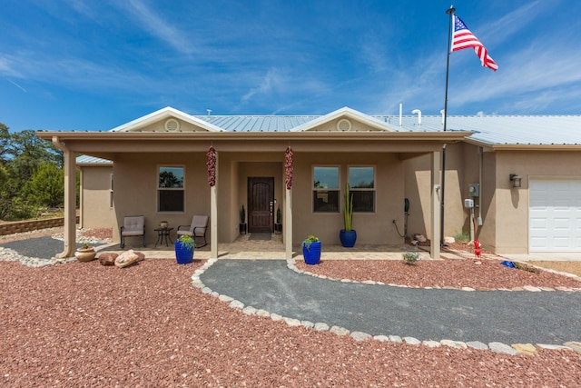 31 Express Blvd, Sandia Park, NM 87047 - view of front of house with stucco siding, a porch, and metal roof
