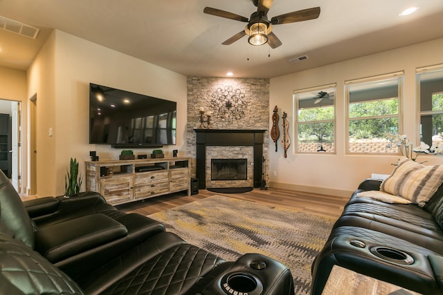31 Express Blvd, Sandia Park, NM 87047 - living area featuring ceiling fan, a stone fireplace, wood finished floors, and baseboards