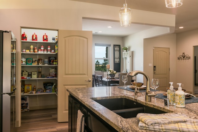 31 Express Blvd, Sandia Park, NM 87047 - kitchen featuring a sink, freestanding refrigerator, wood finished floors, light stone countertops, and decorative light fixtures