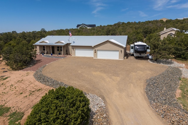 31 Express Blvd, Sandia Park, NM 87047 - single story home with dirt driveway, a garage, covered porch, stucco siding, and metal roof
