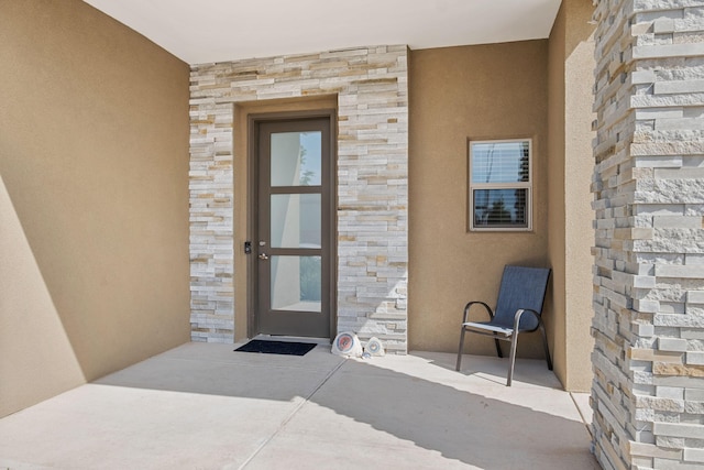 6527 Trestle Glen Rd NW, Albuquerque, NM 87120 - doorway to property with stone siding and stucco siding