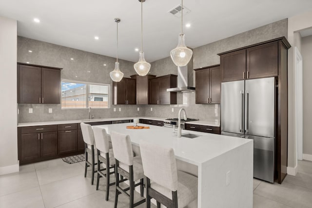 6527 Trestle Glen Rd NW, Albuquerque, NM 87120 - kitchen featuring high end refrigerator, dark brown cabinets, tasteful backsplash, light countertops, and a kitchen island with sink