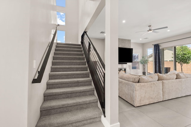 6527 Trestle Glen Rd NW, Albuquerque, NM 87120 - stairs with a ceiling fan, recessed lighting, and a glass covered fireplace