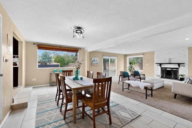 3801 Simms Ave SE, Albuquerque, NM 87108 - dining room featuring a stone fireplace, light tile patterned flooring, and beam ceiling