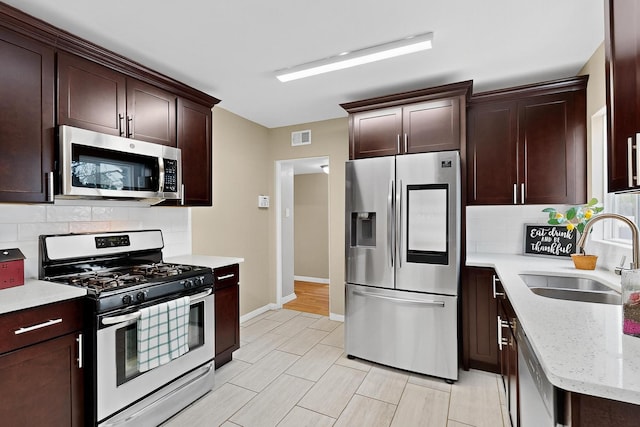 3801 Simms Ave SE, Albuquerque, NM 87108 - kitchen with stainless steel appliances, backsplash, light stone counters, and dark brown cabinets
