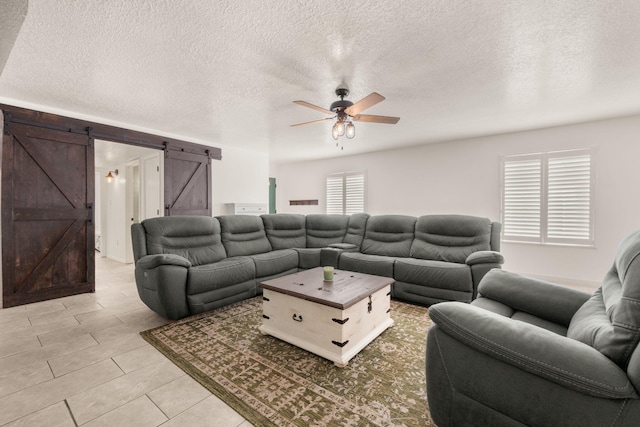 3758 Cattle Dr NE, Rio Rancho, NM 87144 - living room featuring a barn door, a ceiling fan, light tile patterned floors, and a textured ceiling