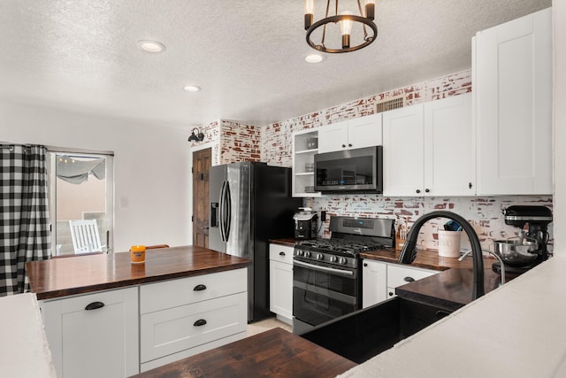 3758 Cattle Dr NE, Rio Rancho, NM 87144 - kitchen featuring stainless steel appliances, wooden counters, a textured ceiling, a chandelier, and open shelves