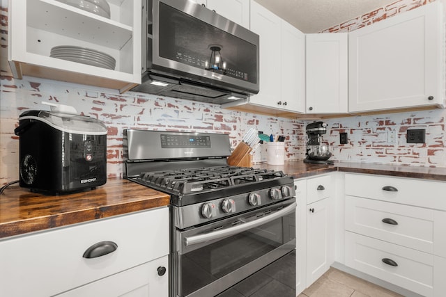 3758 Cattle Dr NE, Rio Rancho, NM 87144 - kitchen featuring stainless steel appliances, butcher block counters, open shelves, light tile patterned floors, and white cabinets