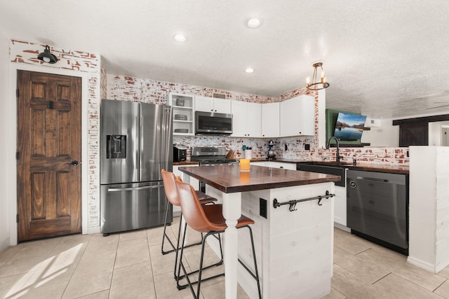 3758 Cattle Dr NE, Rio Rancho, NM 87144 - kitchen with appliances with stainless steel finishes, wooden counters, white cabinetry, light tile patterned flooring, and recessed lighting
